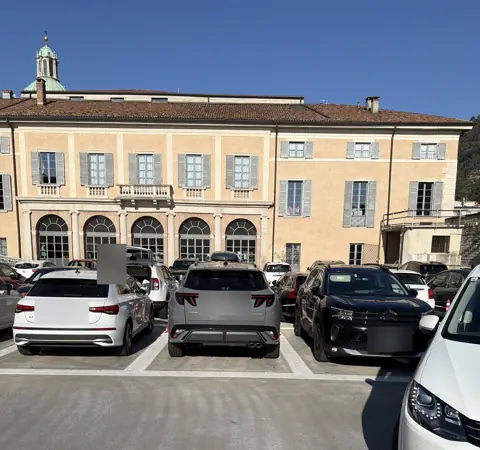 Samochody zaparkowane przed fasadą Teatro Sociale