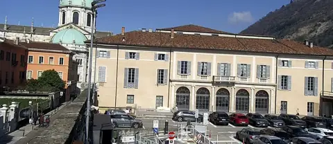 Wjazd na parking od Via Bellini z katedrą i Teatro Sociale